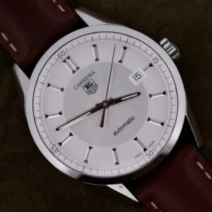 A Tag Heuer Carrera Caliber 5 Automatic WV211A.FC6203 with a silver case, brown leather strap, and the date displayed as the 15th.