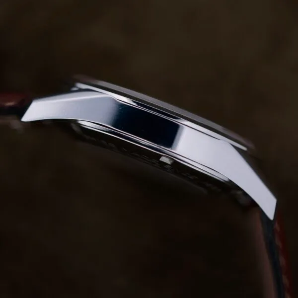 Side view of the Tag Heuer Carrera Caliber 5 Automatic Wv211A.Fc6203 with a polished metal case and leather strap. The dark background highlights its shine, adding timeless elegance to the watchs classic design.