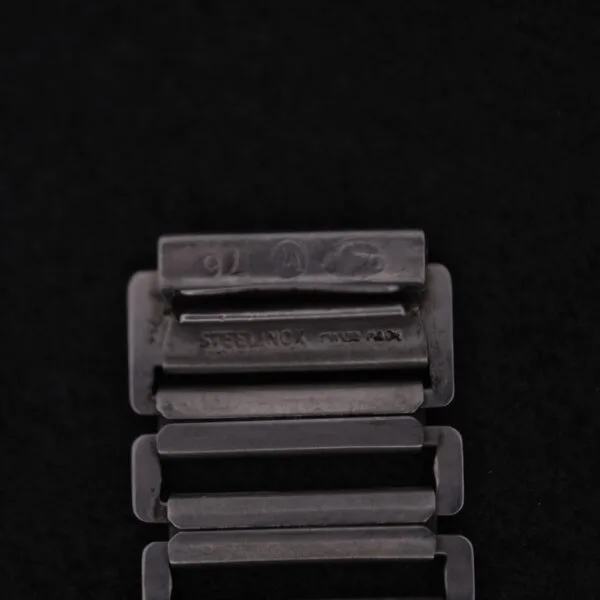 Close-up of an Omega WWII Era Military Sub Seconds watch band with rectangular metal links against a black background, elegantly engraved with STEELINOX and SWISS MADE, reflecting timeless craftsmanship.