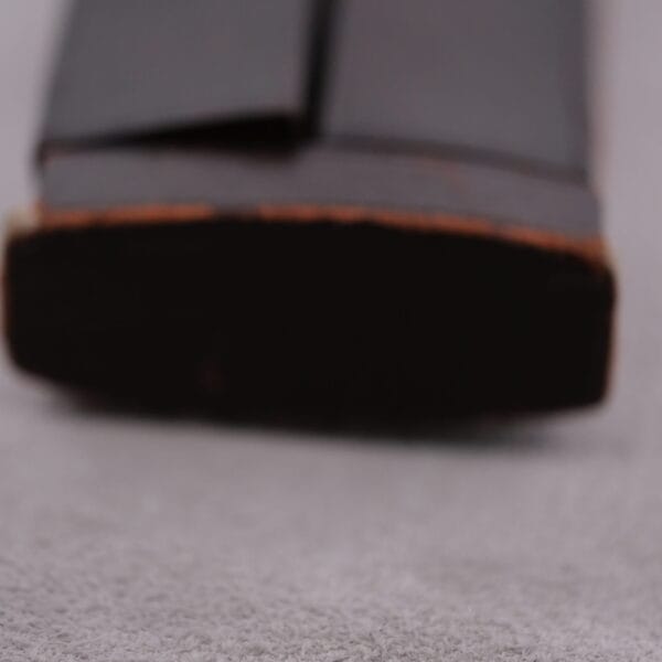 Close-up of a black shoe sole on a light gray surface, capturing the precision of a Vacheron Constantin 6761 Cal 1003. The heel is in the foreground, with the rest slightly blurred, highlighting its thick and slightly worn sole.