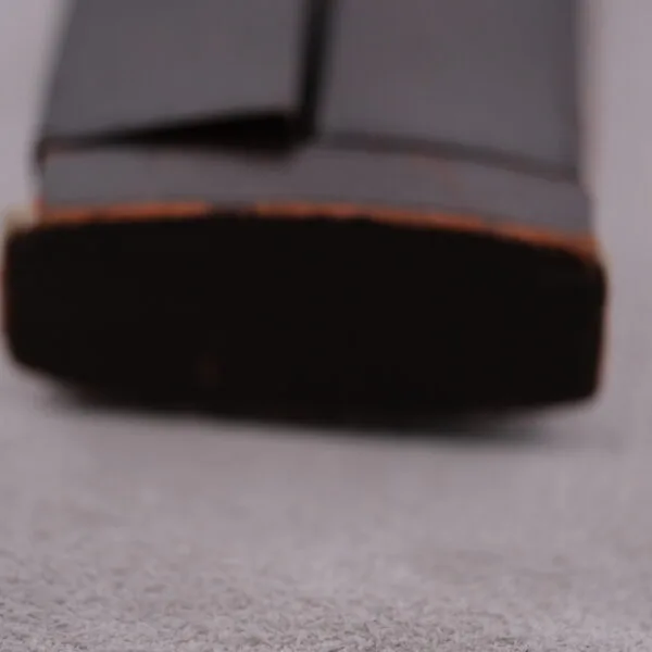 Close-up of a black shoe sole on a light gray surface, capturing the precision of a Vacheron Constantin 6761 Cal 1003. The heel is in the foreground, with the rest slightly blurred, highlighting its thick and slightly worn sole.