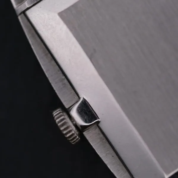 Close-up of the Vacheron Constantin 6761 Cal 1003s silver crown, located on the right side of a brushed metal case against a dark background, with its textured edge prominently visible.