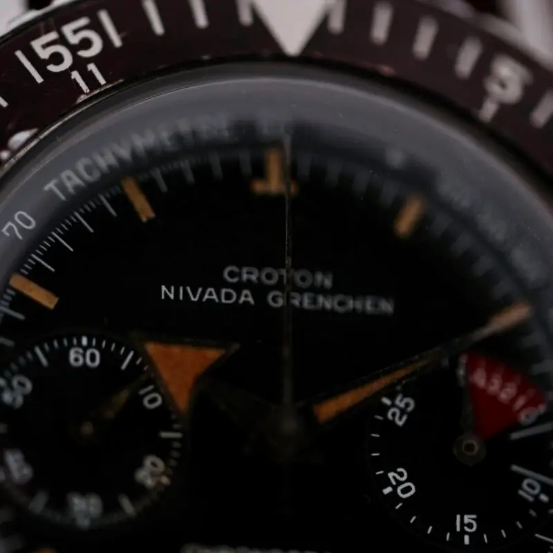 Nivada Gretchen Croton Chronograph - The 1960s Croton Chronograph Aviator Sea Diver with Broad Arrow hands is a versatile and historically significant timepiece, designed for both aviation and diving. Manufactured in Switzerland, this manual wind watch features a robust stainless steel case (38.6mm width, 18mm lug width) and a black dial with striking Broad Arrow hands for enhanced legibility. It includes chronograph functions, small seconds, and a triple register. Though it comes without original box and papers, it includes a one-year warranty and an Ottuhr travel box and pouch. This watch embodies the adventurous spirit of the 1960s, making it a prized possession for enthusiasts.