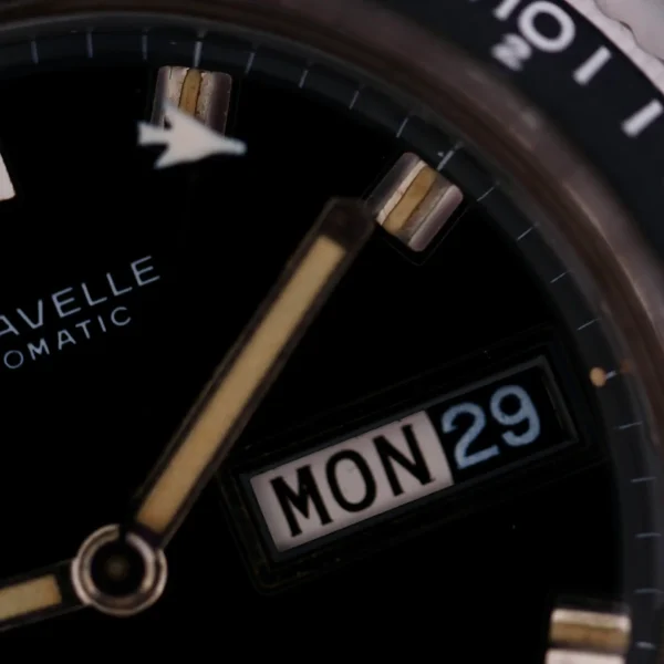 Close-up of the Caravelle Automatic Ref 745 Diver “Jet Seconds” watch face, highlighting gold-toned hands with sleek indices. The name Caravelle is elegantly displayed alongside Automatic, and the date window shows MON 29.