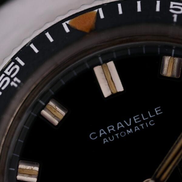 Close-up of a Caravelle Automatic Ref 745 Diver “Jet Seconds” Super Waterproof watch face with a black dial, luminous rectangular hour markers, and silver bezel marked numerically and highlighted with a triangle at the 12 oclock position.