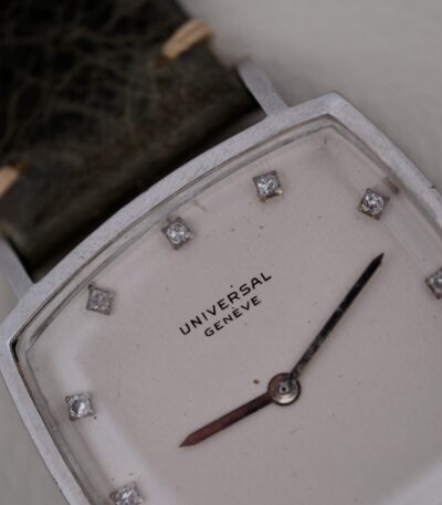 Introducing the Universal Geneve White Diamond Dial Micro-Rotor Cal. 66, a timeless masterpiece from the esteemed Swiss watchmaker, Universal Geneve. Crafted between 1960 and 1969, this exquisite timepiece embodies the pinnacle of Swiss horological excellence. The watch features a sophisticated 31mm stainless steel case, perfectly sized for both elegance and comfort. Its pristine white dial is adorned with meticulously set diamonds, adding a touch of luxury and refinement. The silver-tone hands and markers provide a striking contrast, ensuring easy readability while enhancing the watch's classic aesthetic. At the heart of this remarkable timepiece lies the Caliber 66 automatic movement, renowned for its precision and reliability. The innovative micro-rotor design allows for a slimmer profile, making it a marvel of engineering and craftsmanship. The Universal Geneve White Diamond Dial Micro-Rotor Cal. 66 is paired with a high-quality leather strap, offering both durability and sophistication. The 18mm width of the strap ensures a secure and comfortable fit on the wrist. This watch does not feature a date function, allowing the purity of its design to shine through. It is a testament to Universal Geneve's commitment to creating timeless pieces that transcend trends and remain cherished heirlooms. Embrace the elegance and heritage of Swiss watchmaking with the Universal Geneve White Diamond Dial Micro-Rotor Cal. 66, a true collector's item that exudes sophistication and style.