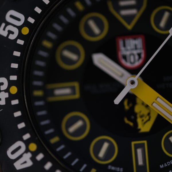 Close-up of a Luminox Scott Cassell Deep Dive Special 1526 Automatic watch face with black, yellow, and white details. It features large luminous markers, bold hands, numbers on the bezel, and a logo at the top center.