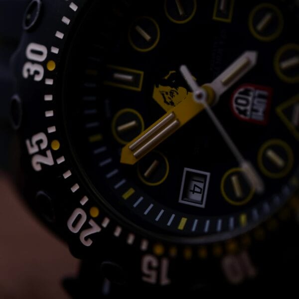 A close-up of the Luminox Scott Cassell Deep Dive Special 1526 Automatic wristwatch showcases its black face with white numbers and yellow accents, luminous hands and markings, a date window, and a rotating bezel with numeric increments.