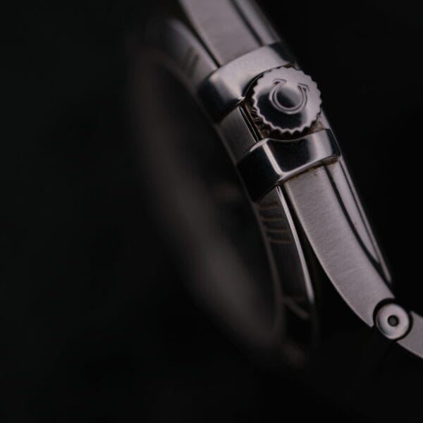 Close-up of the Omega Constellation Ref. 396.201, set against a dark background, with focus on its polished metal strap and intricately designed crown.