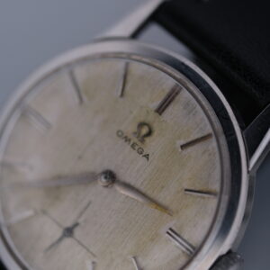 Omega - The 1960 Omega Ref. 14713 Manual Wind Cal. 268 is a vintage timepiece epitomizing Omega's mid-century elegance and precision. With a 34mm stainless steel case and a textured silver dial, it features minimalist design elements like baton markers and slender hands. Powered by the reliable Caliber 268 manual wind movement, part of Omega's esteemed 30M series, this watch is celebrated for its durability and accuracy. It includes a leather strap, small seconds feature, and comes with an Ottuhr travel box, pouch, and a 1-year warranty, making it a prized piece for collectors.