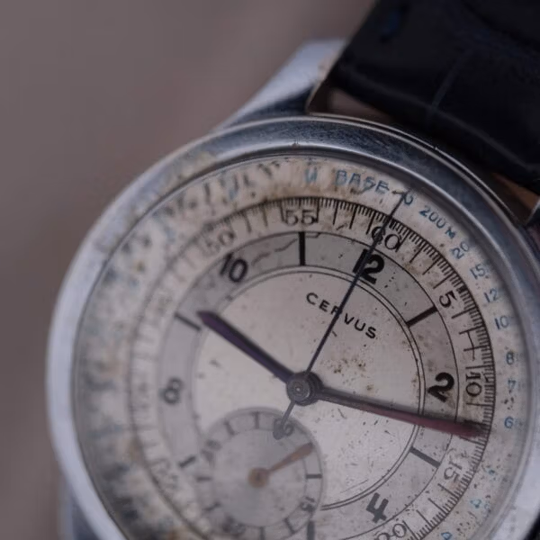 Cervus chronograph upper dial macro highlighting cathedral blued hands, black Arabic numerals, and outer chapter ring scales