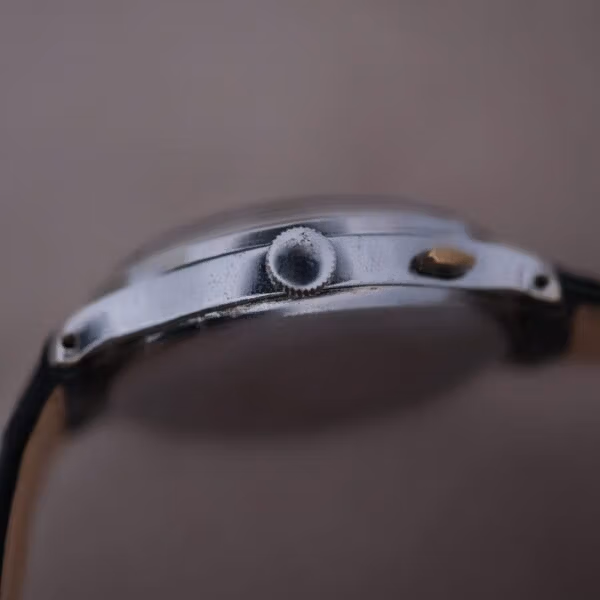 Side profile of Cervus chronograph case showing coin-edge crown, monopusher case construction, and downturned polished lugs