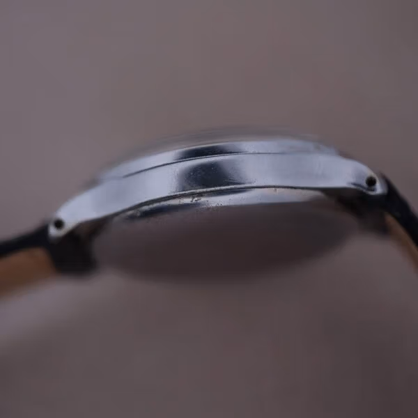 Caseback exterior of Cervus monopusher chronograph showing plain polished snap-back, honest patina, and crown protruding from case side