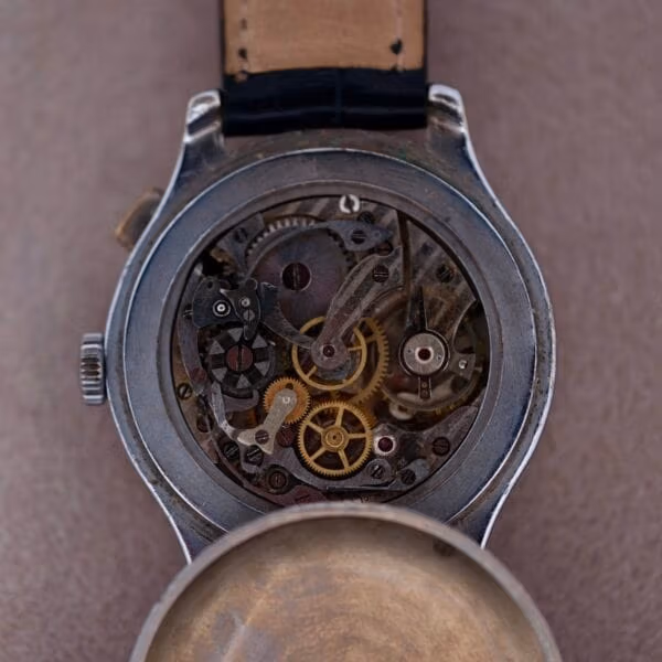 Chronograph movement of Cervus monopusher revealing exposed brass gears, chronograph levers, and case interior architecture