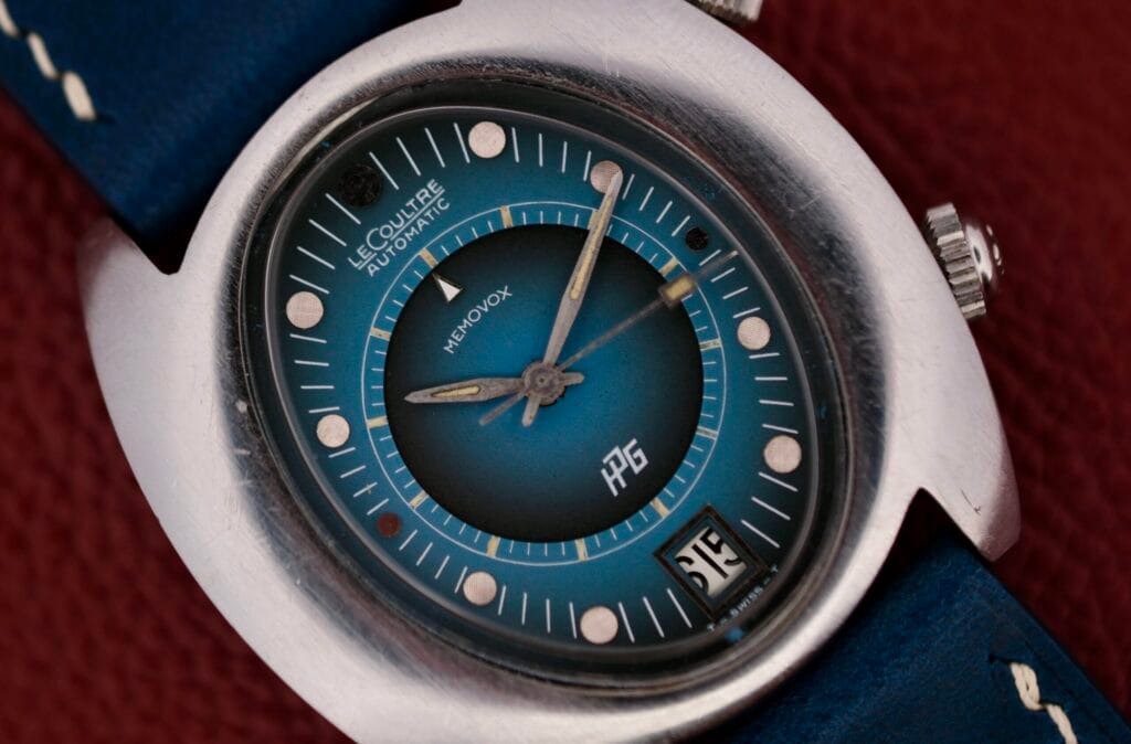A close-up of a blue 1971 Jaeger LeCoultre Memovox ’Egg’ wristwatch with a date window at 3 oclock.