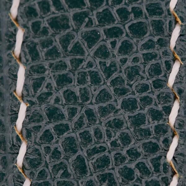 Close-up of a textured Handmade Olive Green Epson Leather Watch Strap with a crocodile skin pattern. Two parallel white stitching lines run vertically, contrasting with the dark green leather texture.