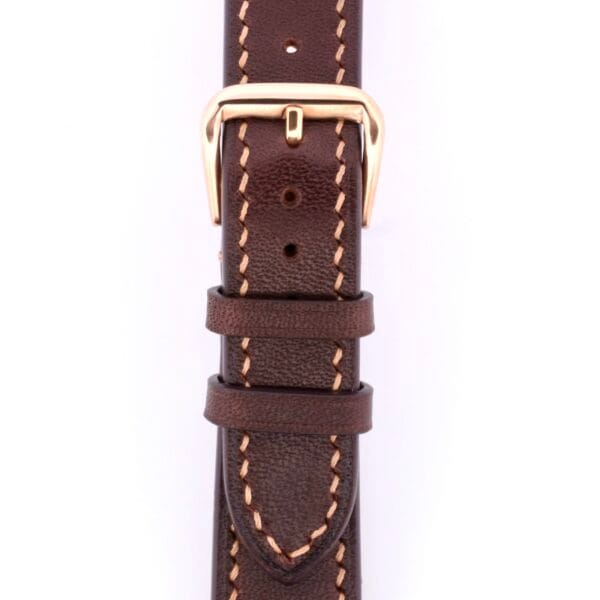 Close-up of a Dark Brown Genuine Horween Shell Cordovan watch strap with beige stitching. The strap includes a gold buckle and is elegantly displayed flat on a pristine white background.