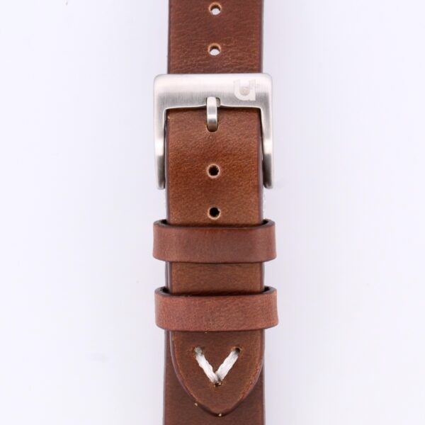 Close-up of the Vintage Calf Leather Watch Strap Single End Stitch, crafted from brown leather with a silver buckle. It offers multiple adjustment holes and two loops for securing excess length, embodying timeless elegance.