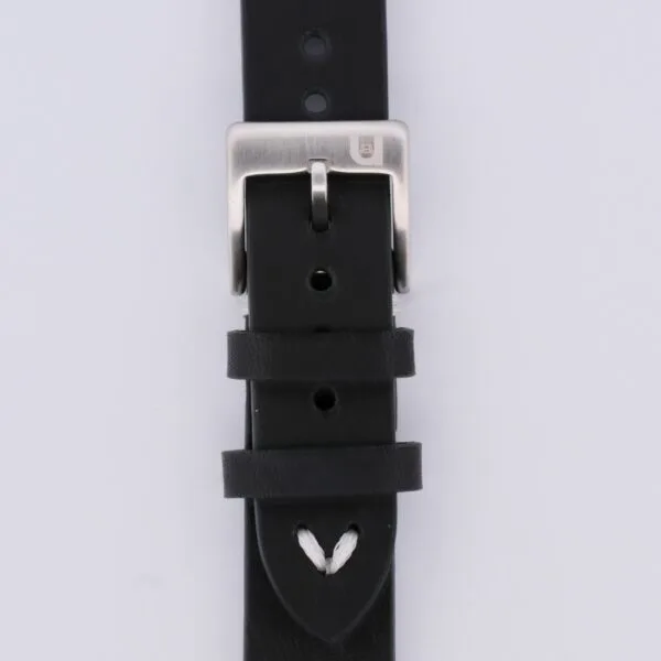 Close-up of a black Vintage Calf Leather Watch Strap Single End Stitch, featuring a silver buckle. Its white stitching enhances its classic appeal, while several adjustment holes and two loops efficiently manage excess strap length.