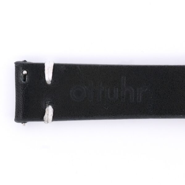 Close-up of the Vintage Calf Leather Watch Strap Single End Stitch in black leather with white stitching and otuhr embossed, exuding a vintage watch aesthetic. The strap is displayed horizontally against a crisp white background.