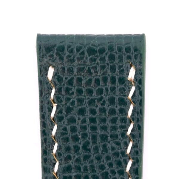 A close-up of a handmade watch strap in olive green Epson leather, featuring white stitching and a crocodile skin-like texture.