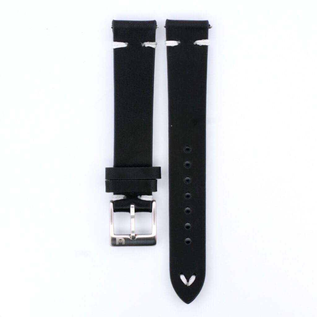 This vintage watch accessory features a black leather strap with a silver buckle. Multiple holes ensure adjustable sizing. The strap is displayed laid out flat against a white background, with both parts neatly side by side.