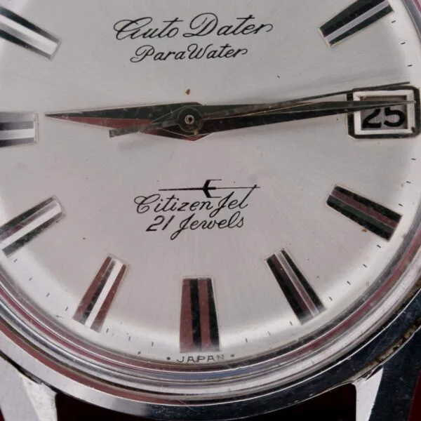 Close-up of a Citizen Jet Auto Dater Automatic Para Water watch face with 21 Jewels and date in a small window on the right, featuring metallic hour markers and hands. Made in Japan.