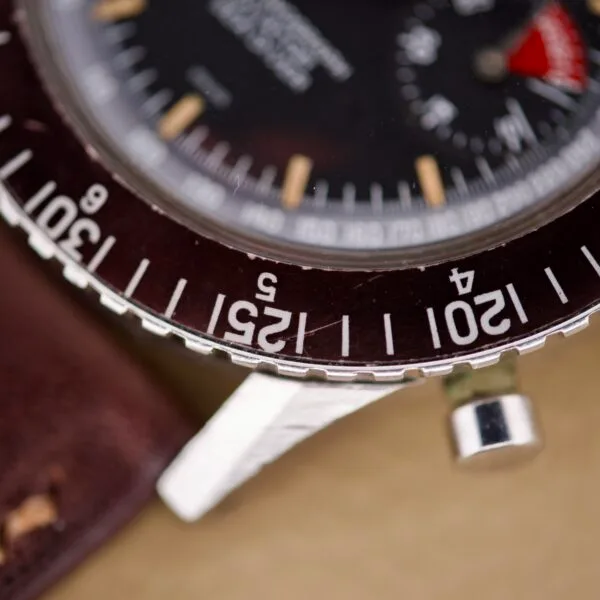 Close-up of a vintage Nivada Grenchen Aviator Sea Diver Chronograph 1st Gen bezel, displaying minute markers and part of the black dial.