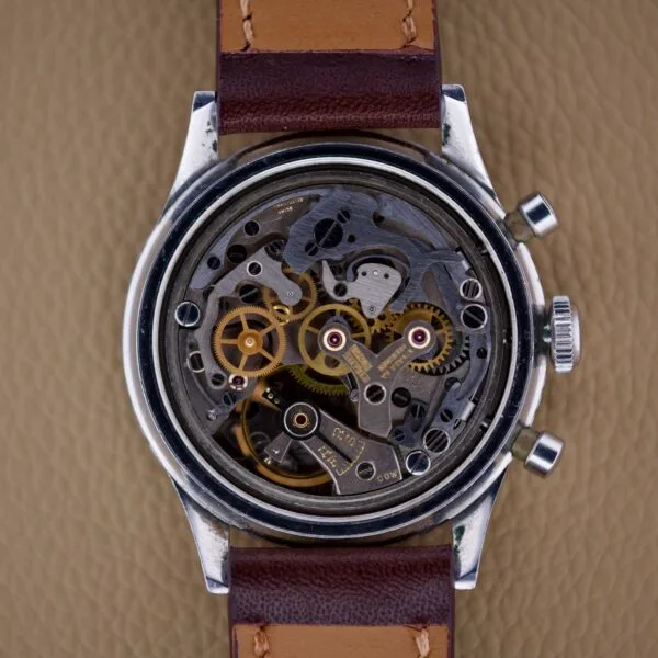 Close-up of a vintage Nivada Grenchen Aviator Sea Diver Chronograph 1st Gen watchs exposed mechanical gears and components, paired with a brown leather strap.