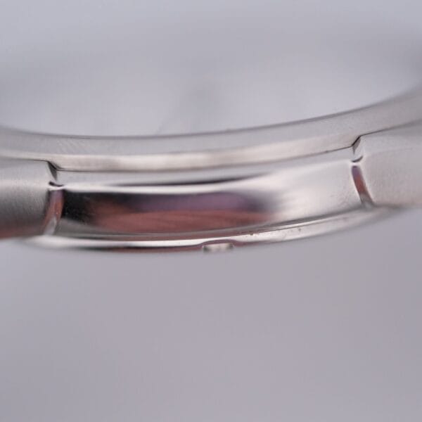 Close-up of a Hamilton Jazz Master Stainless Steel watch case, showcasing the smooth and polished surface. The image emphasizes the side profile, highlighting the sheen and craftsmanship that make this timepiece truly exceptional.