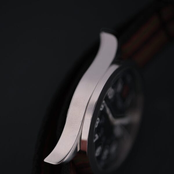 Close-up of a Swiss Army Day/Date Field Watch Swiss Made, featuring a black dial. The focus is on the polished metal edge, showcasing its smooth design against a dark background.