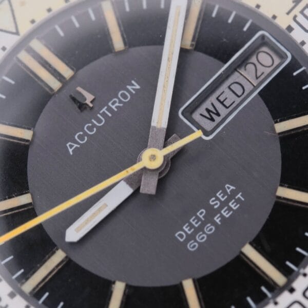 Close-up of a vintage Bulova Accutron Deep Sea 666 “Devil Diver” Inner Bezel watch with a black dial, gold and white hour markers, luminous hands, and a date window showing WED 20.