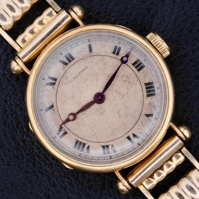 The 1910s Cartier Officer Watch in 18k gold, featuring Roman numerals and an Edmond Jager movement, epitomizes early 20th-century elegance and craftsmanship. This 28mm wide timepiece boasts a white dial with black Roman numerals and blued hands, encapsulating Cartier's refined aesthetic. The involvement of renowned watchmaker Edmond Jager ensures superior mechanical quality. Though it lacks original box and papers, it comes with a one-year warranty and an Ottuhr travel box and pouch. This watch is not just a luxury item but a significant collector's piece, blending Cartier's design excellence with Jager's technical prowess.