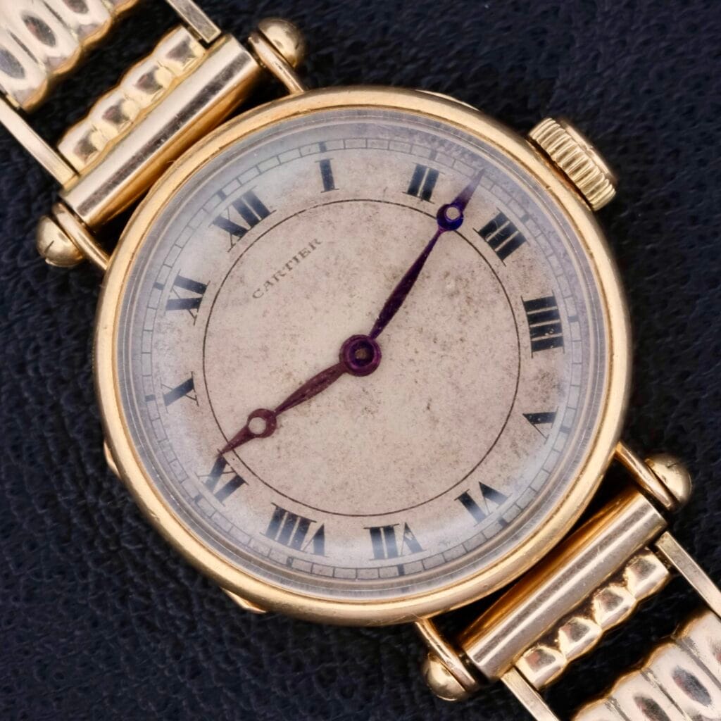 Cartier Officer Watch 18k Gold Roman Numerals Edmond Jager displayed on a black textured background, set to 3:40.