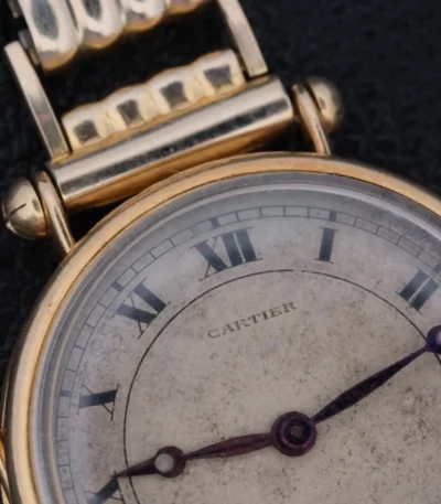 The 1910s Cartier Officer Watch in 18k gold, featuring Roman numerals and an Edmond Jager movement, epitomizes early 20th-century elegance and craftsmanship. This 28mm wide timepiece boasts a white dial with black Roman numerals and blued hands, encapsulating Cartier's refined aesthetic. The involvement of renowned watchmaker Edmond Jager ensures superior mechanical quality. Though it lacks original box and papers, it comes with a one-year warranty and an Ottuhr travel box and pouch. This watch is not just a luxury item but a significant collector's piece, blending Cartier's design excellence with Jager's technical prowess.