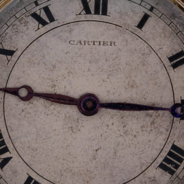 Close-up of a Cartier Officer Watch 18k Gold Roman Numerals Edmond Jager face displaying time as 8:18 with its oxidized hands. The aged, textured surface enhances its vintage allure.