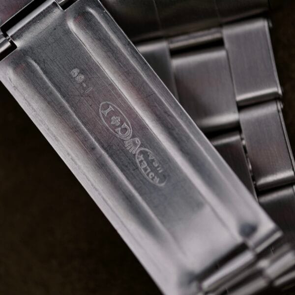 A close-up of the inside clasp on the Rolex Oyster Perpetual Datejust 6605 Cal. 1066 stainless steel bracelet reveals engravings and hallmarks, emphasizing its texture and finishes.