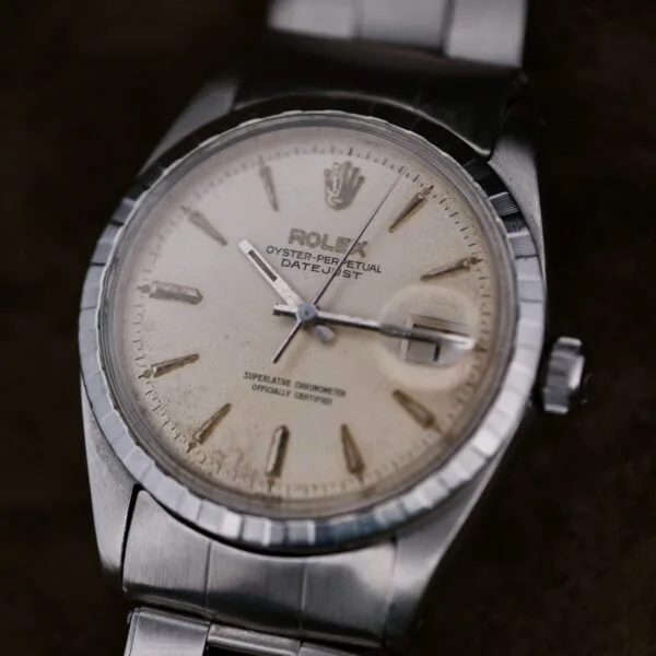 A close-up of the Rolex Oyster Perpetual Datejust 6605 Cal. 1066 exudes elegance with its silver metal band, slightly tarnished white dial, and silver hour markers and hands. The classic Rolex crown logo sits atop the face, epitomizing timeless luxury.