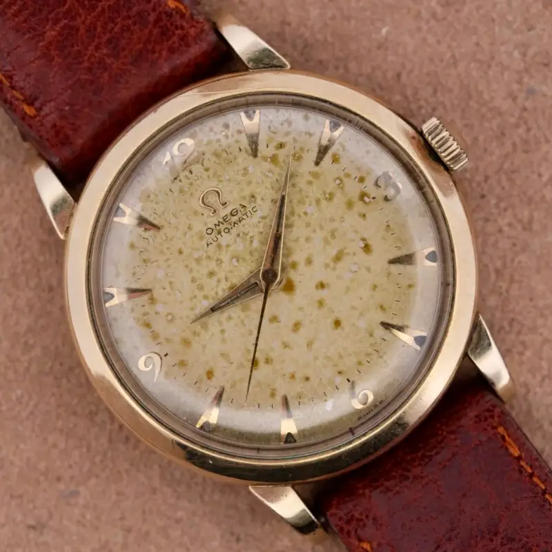 The 1954 Omega Automatic is a vintage masterpiece featuring a unique spotted patina dial and the reliable Caliber 355 movement. Housed in a 34mm 10k gold-filled case with a leather strap, this Swiss-made watch combines historical charm with everyday functionality. Its naturally aged dial adds character, while the central seconds and self-winding features ensure precision. Complete with an Ottuhr travel box, pouch, and a 1-year warranty, this Omega is a testament to timeless watchmaking.