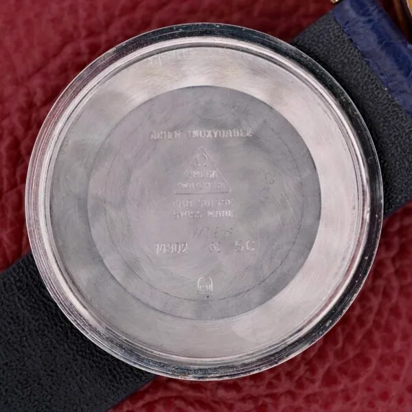 Close-up inside the Omega Constellation Pie-Pan Automatic 561 watch back cover, showing engraved details such as Acier Inoxydable, OMEGA WATCH CO, and FAB. SUISSE SWISS MADE, with various numbers and symbols on a textured background.