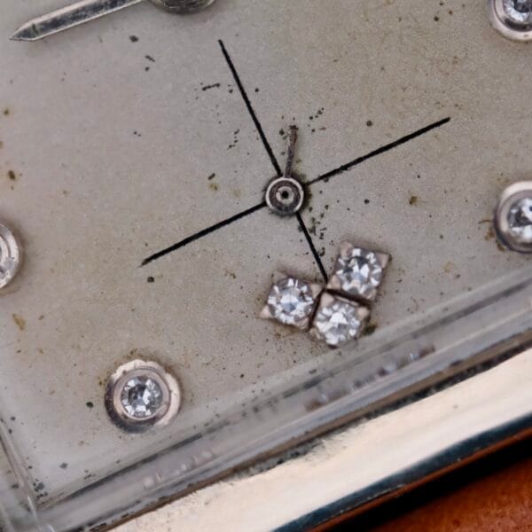 Close-up of the Longines Tank 14k White Gold Diamond Dial Cal. 370, featuring a vintage design with a simple cross formed by a central dot and lines, accented with four small diamonds in the bottom right corner and other sparkling details to enhance its elegance.