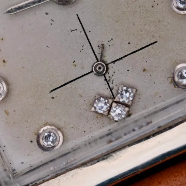 Close-up of the Longines Tank 14k White Gold Diamond Dial Cal. 370, featuring a vintage design with a simple cross formed by a central dot and lines, accented with four small diamonds in the bottom right corner and other sparkling details to enhance its elegance.