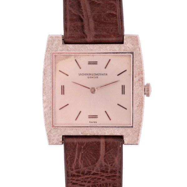 The vintage Vacheron Constantin 6761 Cal 1003 watch features a minimalist rectangular dial with textured metal framing and a brown leather strap, prominently displaying the prestigious brand name on its face.