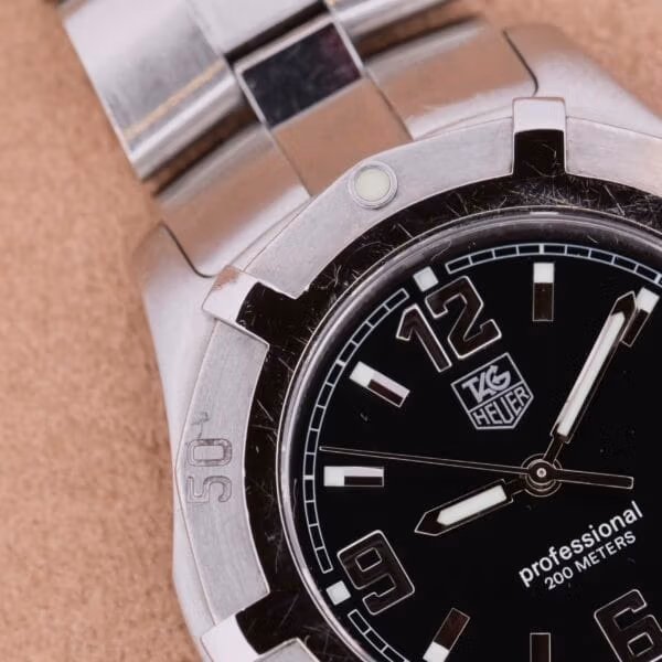 TAG Heuer Professional Dive WN1110-0 close-up of upper dial with shield logo, professional 200 METERS text, sword hands and lume-filled markers on brushed steel
