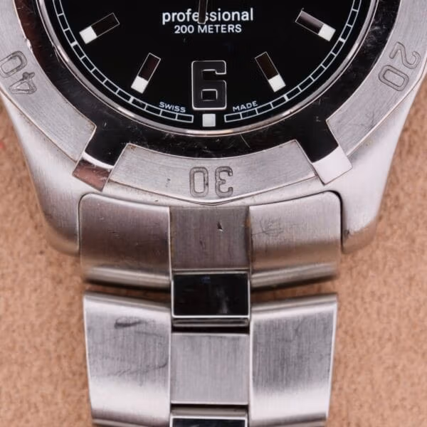 Lower dial close-up of TAG Heuer Professional Dive WN1110-0 showing SWISS MADE text, large applied 6 numeral, engraved bezel numerals 20 and 30, steel bracelet