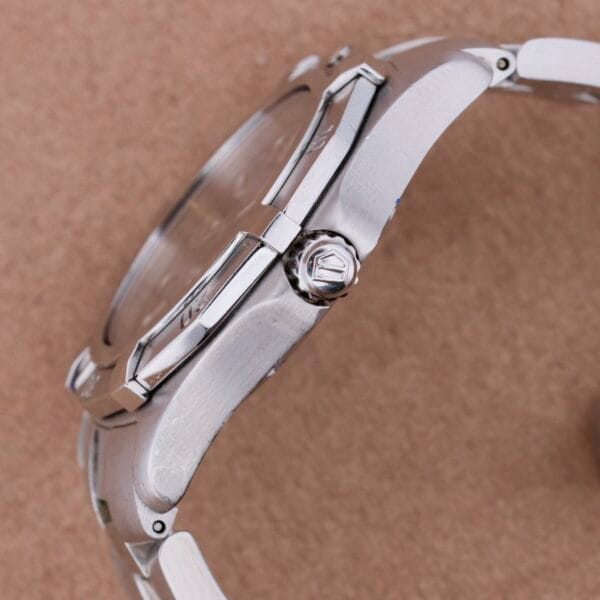 Side view of the Tag Heuer Professional Dive watch set against a brown background, highlighting its polished stainless steel casing, crown, and bracelet.