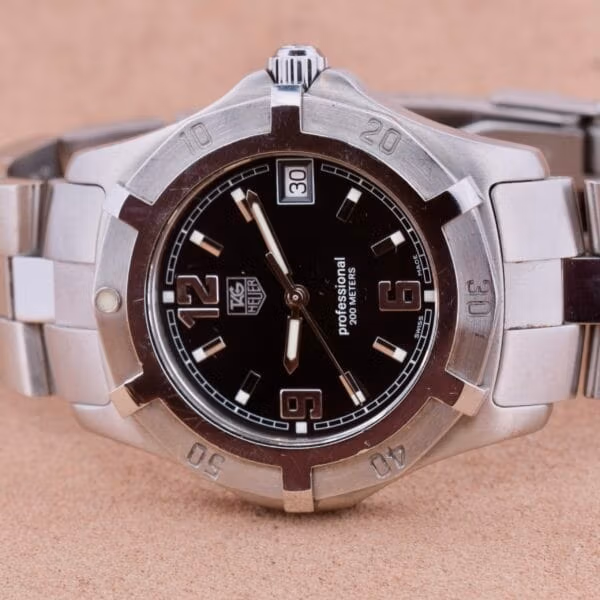 Angled view of TAG Heuer Professional Dive WN1110-0 showing black dial, date at 3, sword hands, scalloped diver bezel with engraved 10 20 30 40 50
