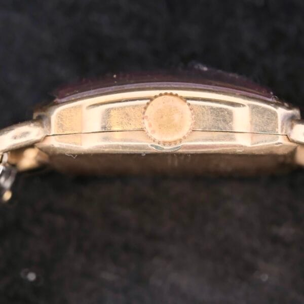 Close-up of a Longines Square Driver Lugs Cal 10L watch case against a black background, focusing on the side profile with its prominent crown and curved structure.
