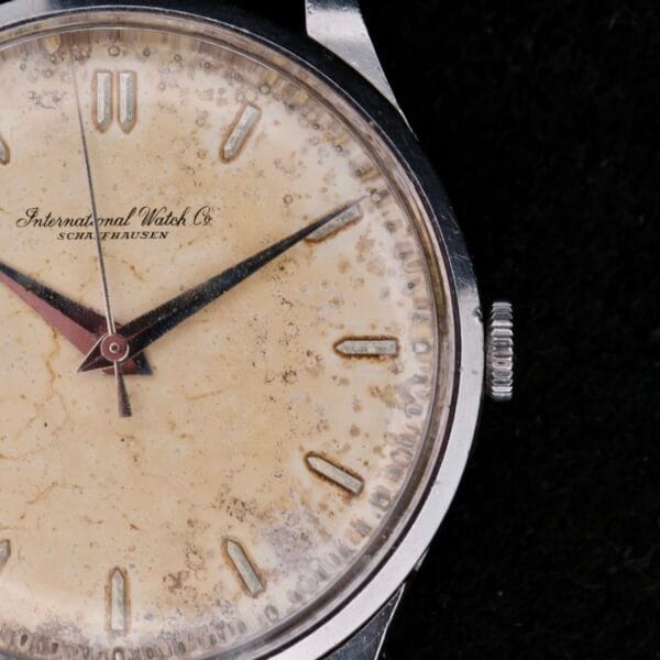 Close-up of a vintage IWC Caltrava Jumbo Cal. 89 Stainless Steel wristwatch featuring a worn, textured cream dial. The face showcases silver hour markers and hands with International Watch Co. and Schaffhausen below the 12 oclock mark.
