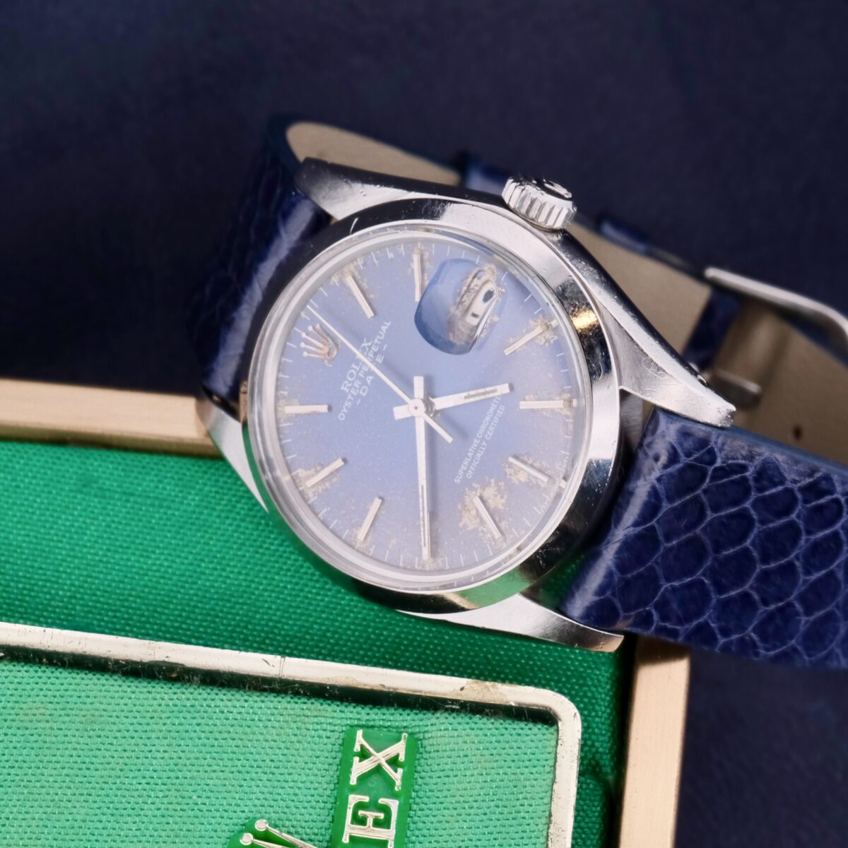 Introducing the Rolex Oyster Perpetual Date Ref 1500 Blue Dial, a Swiss-made masterpiece from the 1970s. This iconic timepiece features a 34mm stainless steel case, a striking blue dial with silver-tone markers, and an automatic movement. It includes a central seconds hand, date function, chronometer certification, hack second feature, and luminescent markers. Paired with an aftermarket leather strap, it offers a 19mm lug width for a comfortable fit. Complete with its original box, outer box, warranty, and manual papers, this watch epitomizes Rolex's enduring excellence and timeless appeal.